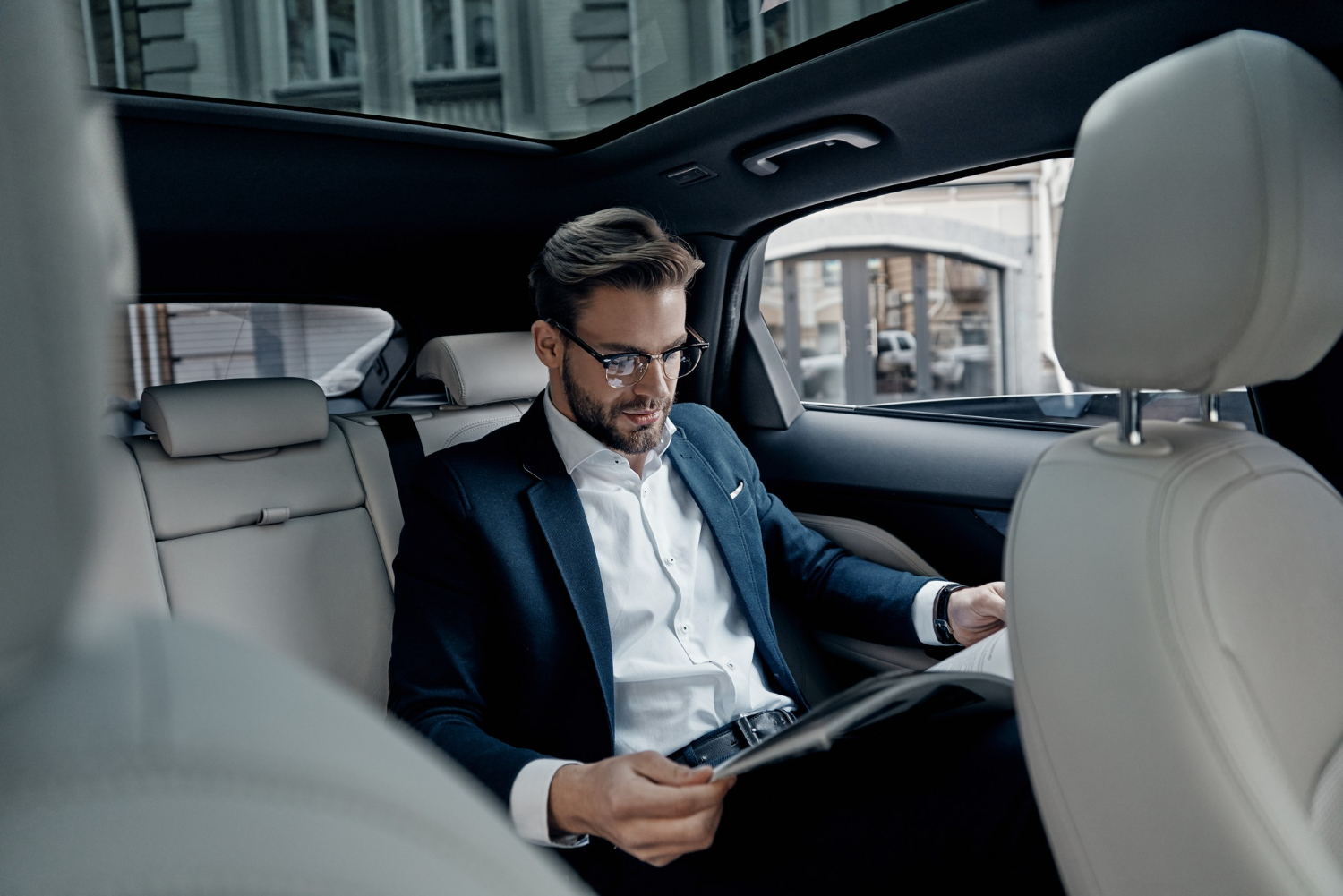 Chauffeur VTC professionnel accueillant un client devant un véhicule haut de gamme.